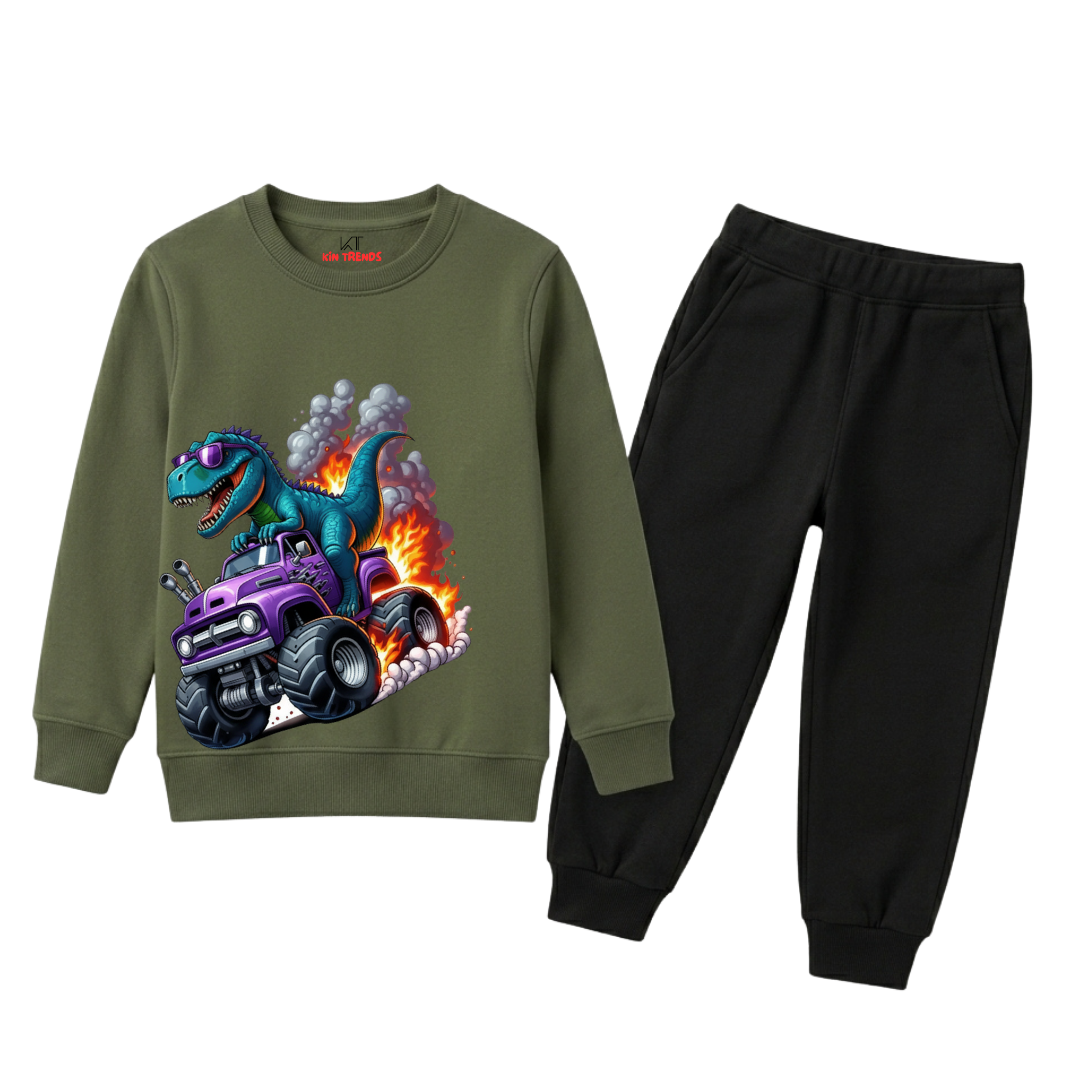 A kids' two-piece sweatshirt and jogger set on a white background. The sweatshirt is olive green with a colorful graphic of a blue dinosaur driving a purple monster truck with flames.